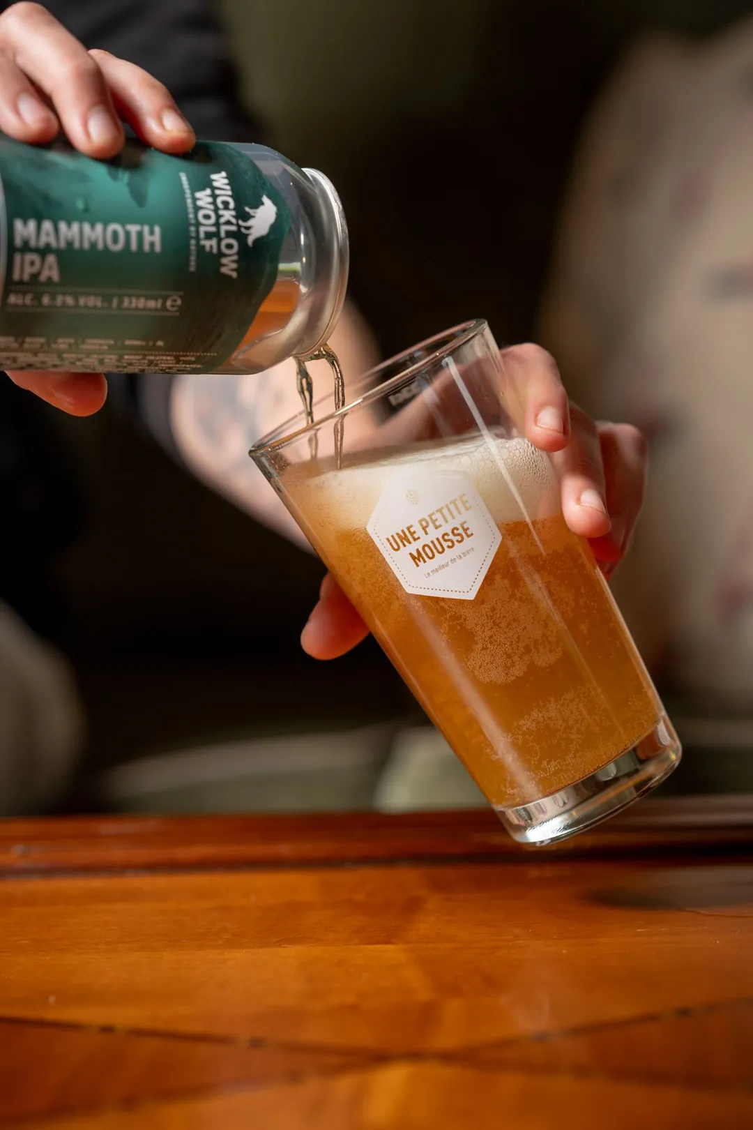Bière versée d'une canette dans un verre gravé