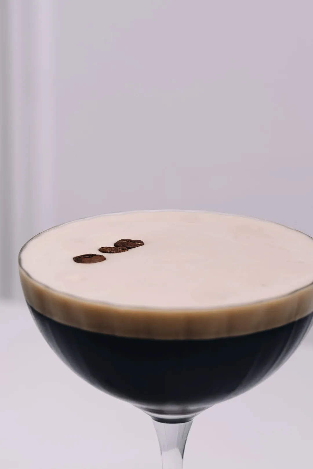 Cocktail mousseux dans une coupe, trois grains de café