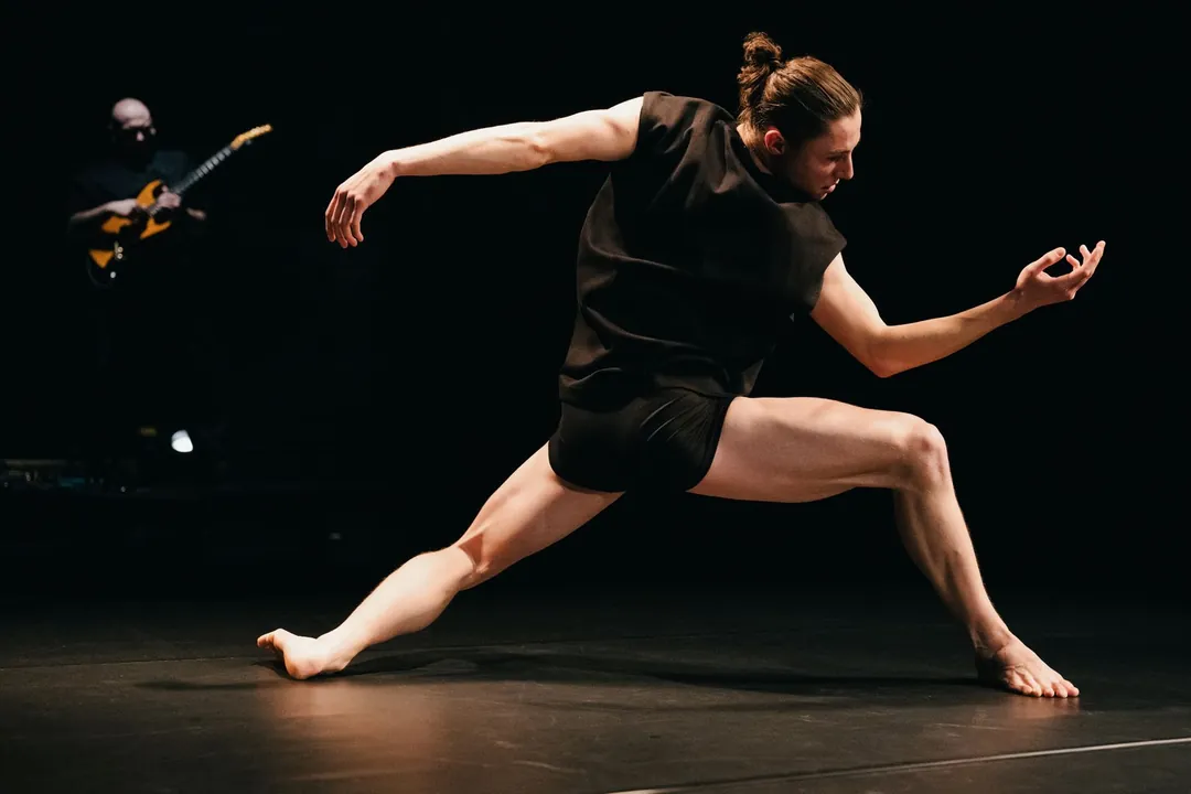 Danseur en extension sur un plateau noir