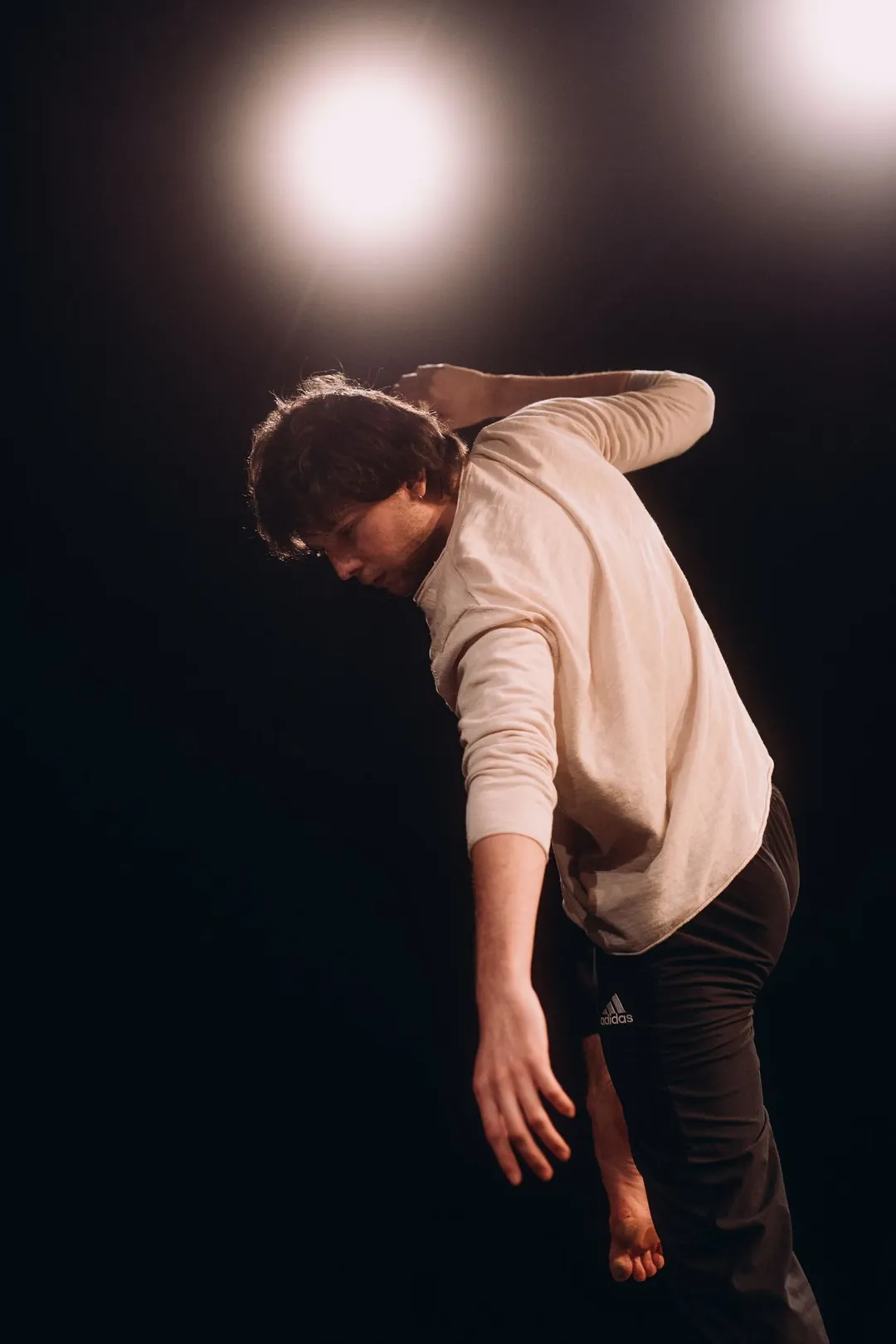 Danseur penché sous deux projecteurs