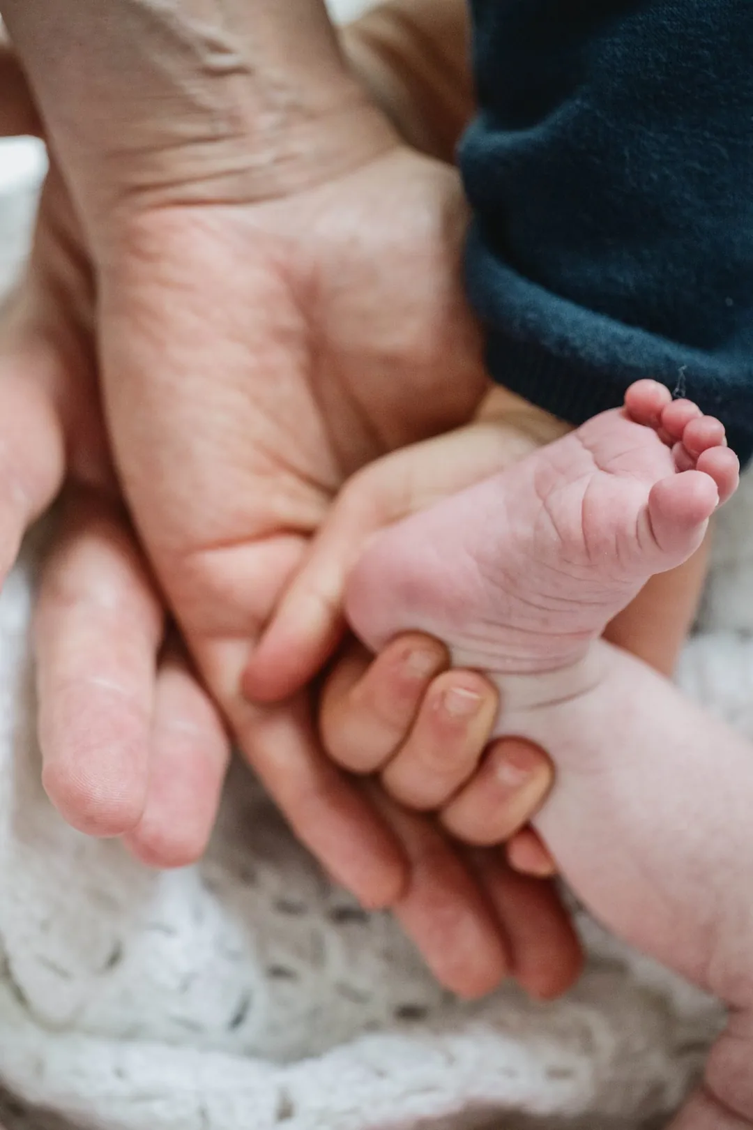 La main d'un parent tient le pied d'un nouveau-né