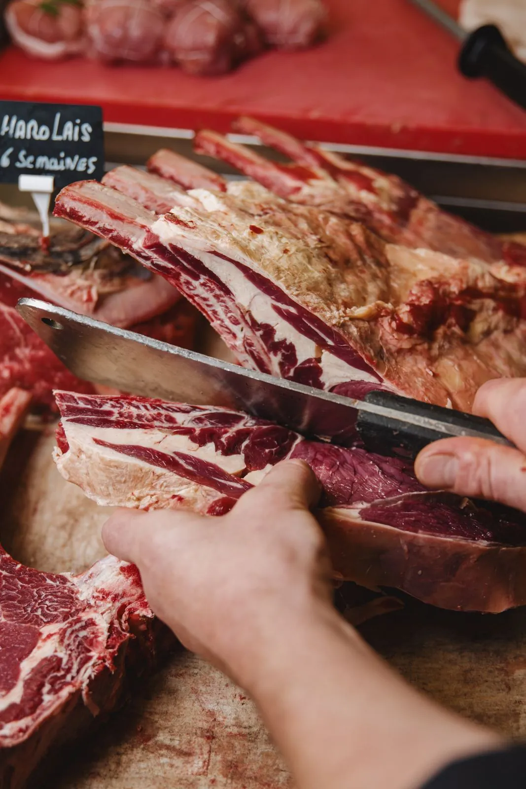 Mains d'un boucher découpant une pièce de viande