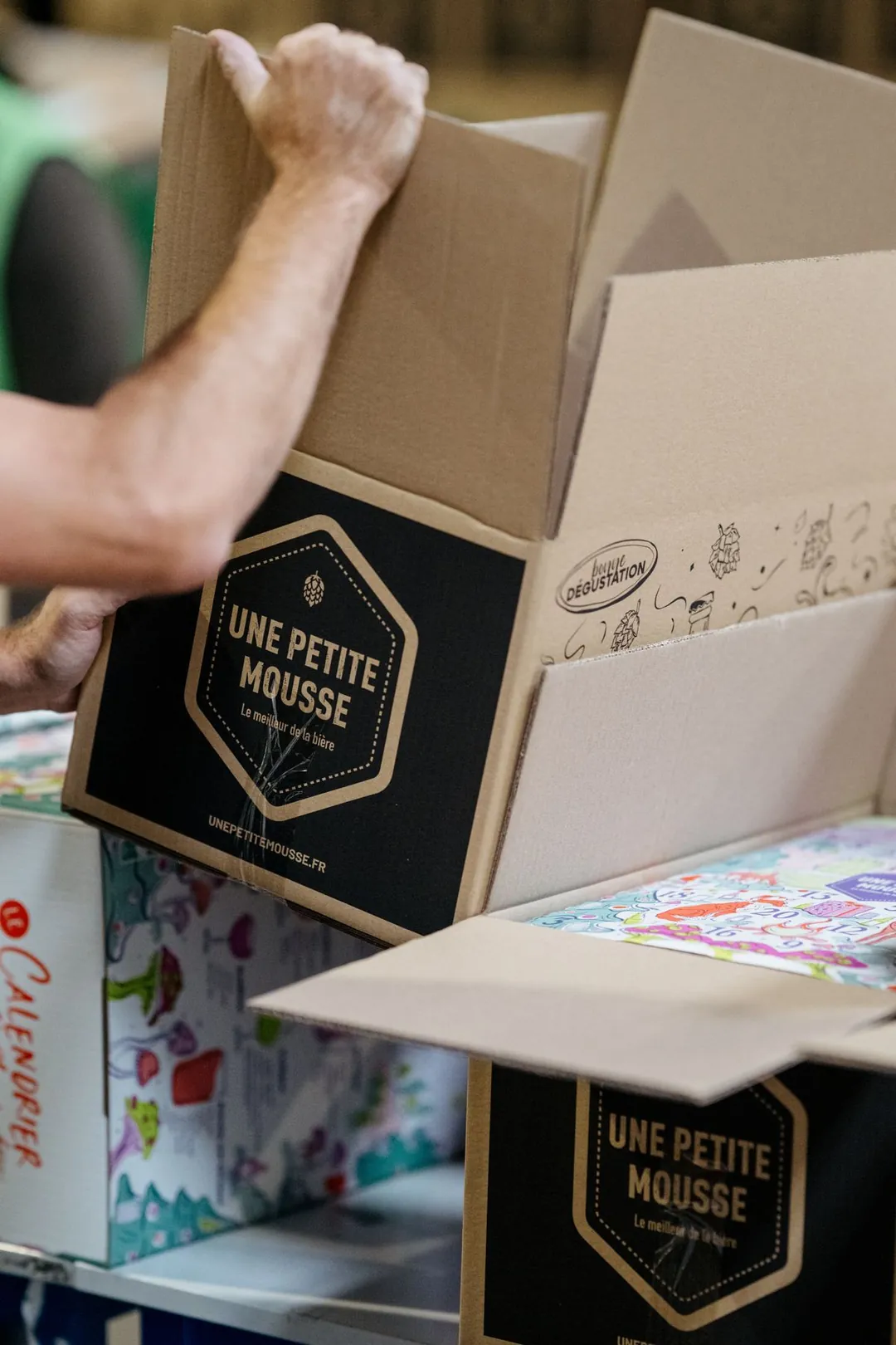 Mains qui sortent un coffret de son carton