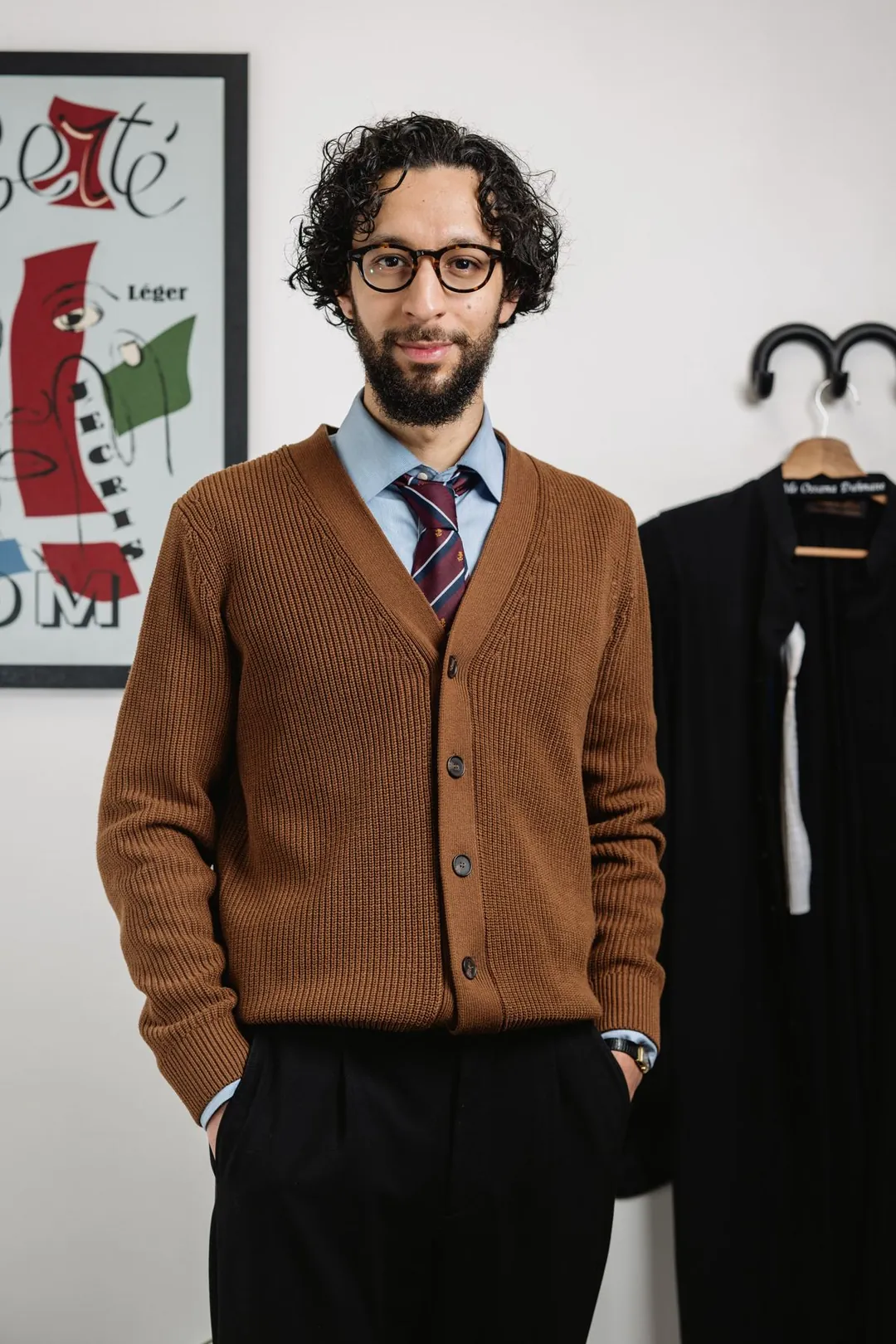 Maître Ossama Dahmane en gilet, devant une affiche