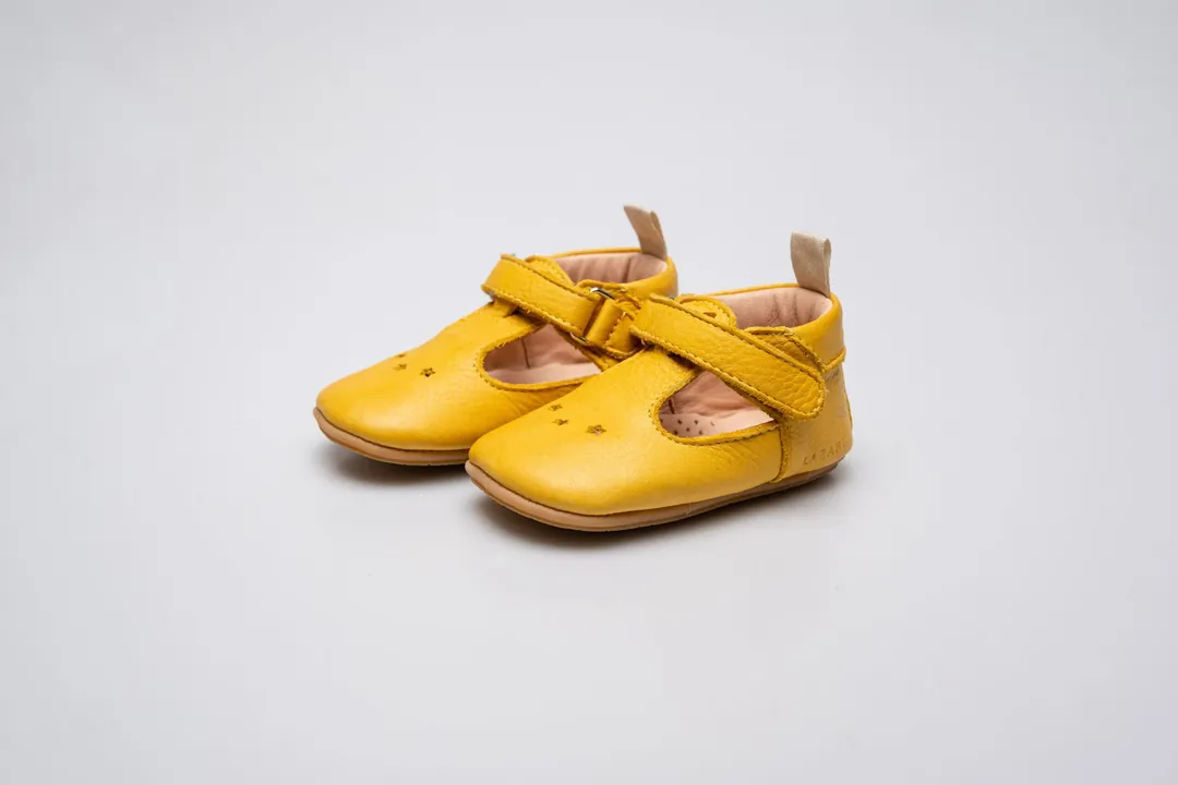 Paire de chaussures jaunes pour enfant sur fond gris