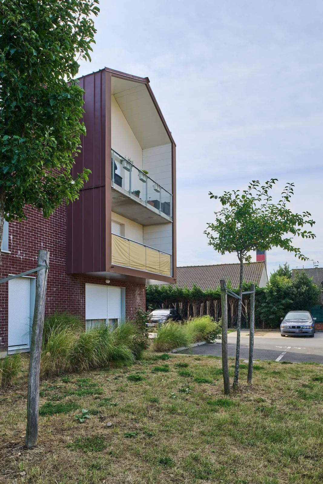 Pignon en bardage et balcons, jardin au premier plan
