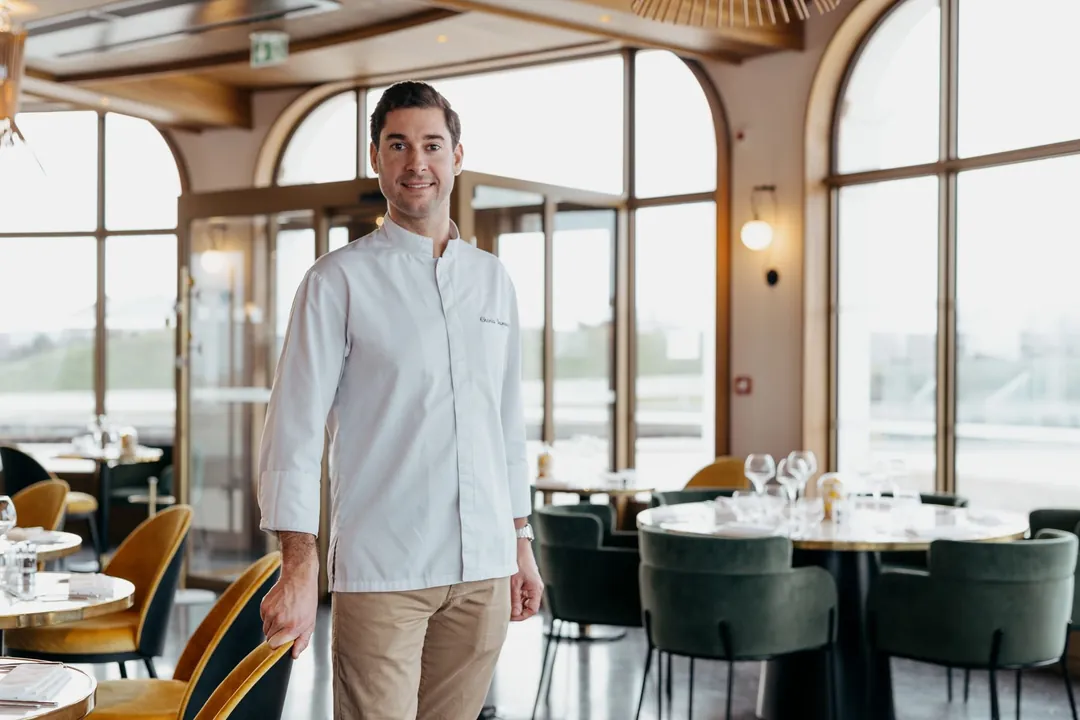 Un chef en veste blanche dans sa salle de restaurant