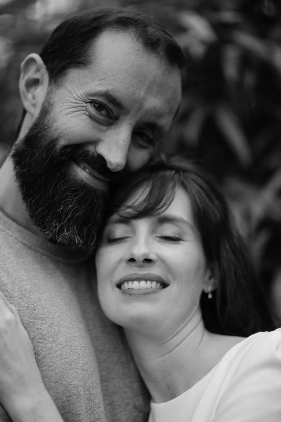 Un couple rit, joue contre joue, en noir et blanc