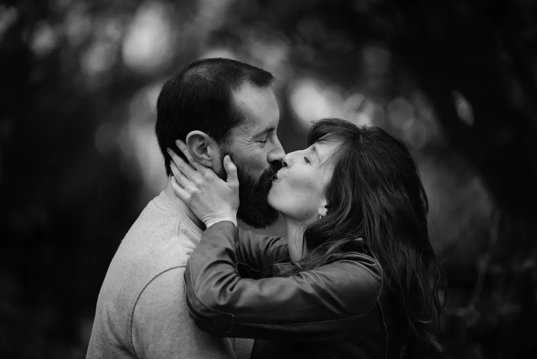 Un couple s'embrasse, en noir et blanc