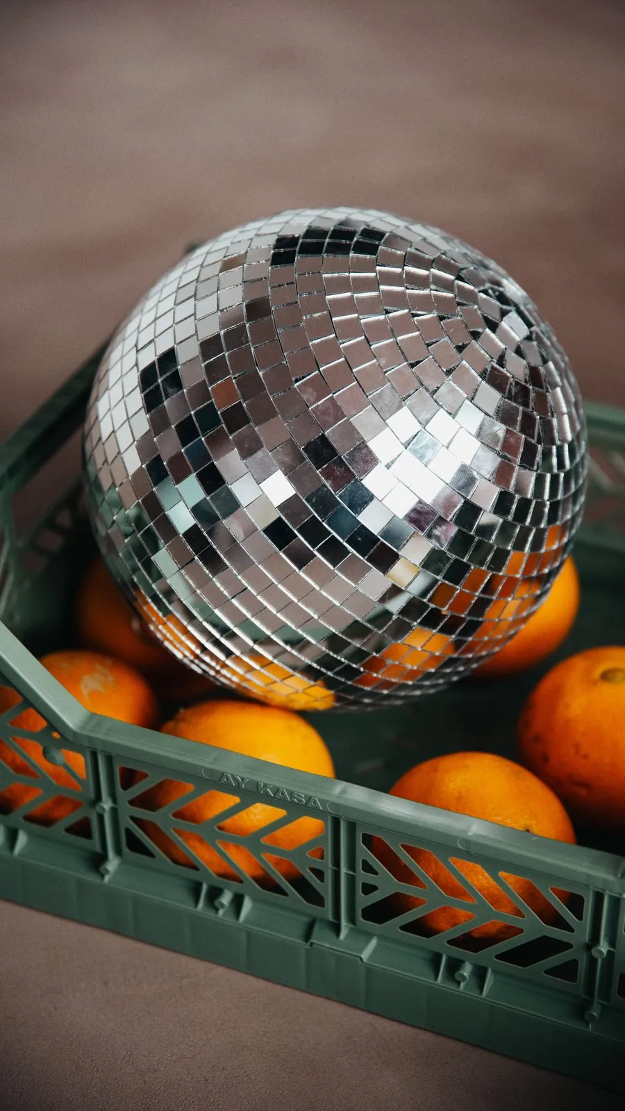 Une boule à facettes posée sur des oranges