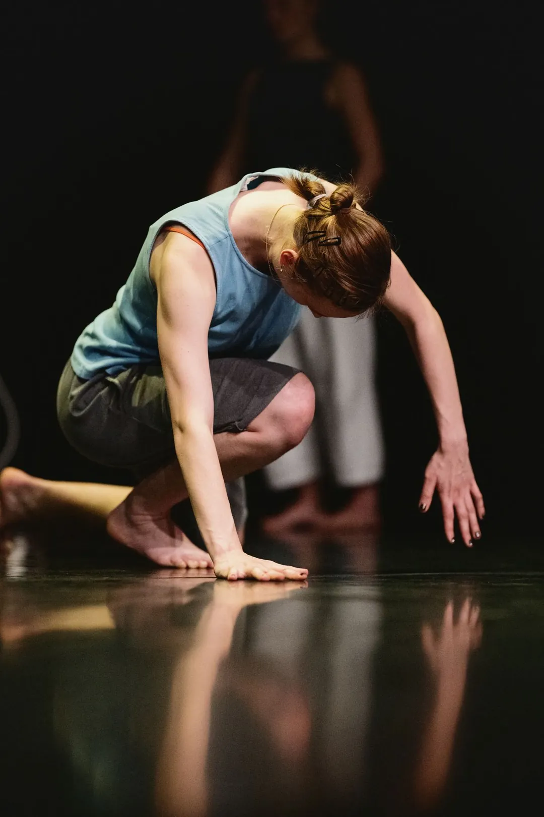 Une danseuse accroupie, reflet sur le sol