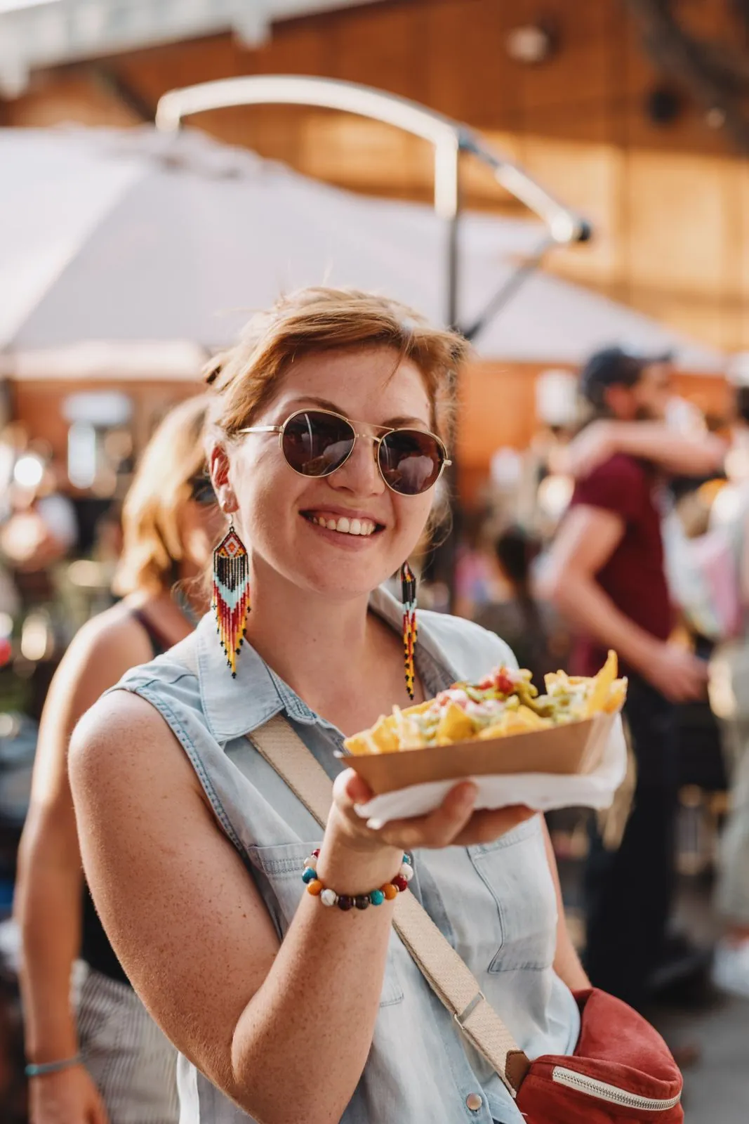 Une femme sourit en montrant son assiette dans la foule